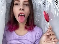 Naughty stepsister sucks a lollipop and show her long hot sexy tongue